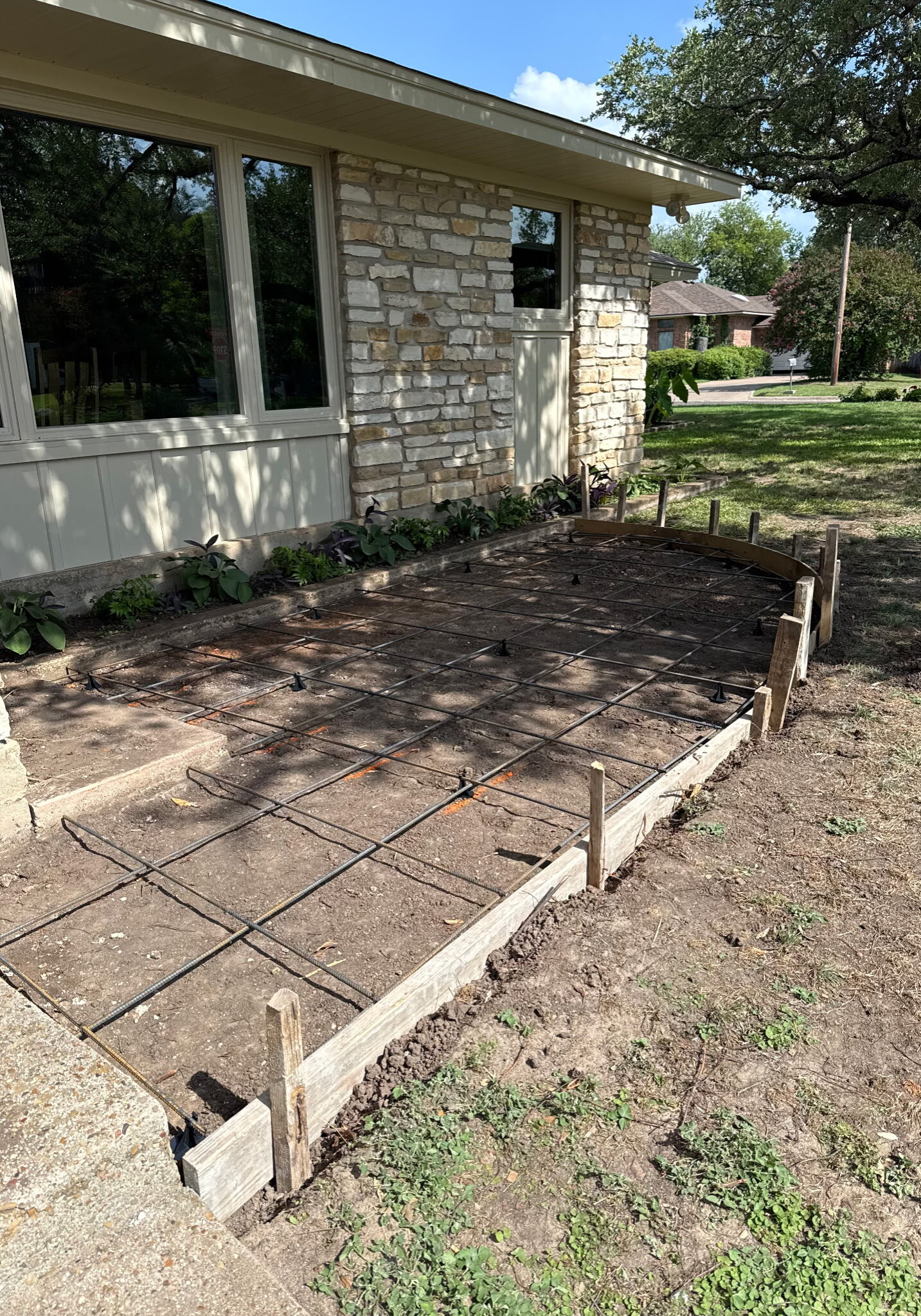 Concrete patio installation with rebar reinforcement and formwork preparation at a residential property in Cleburne, TX.