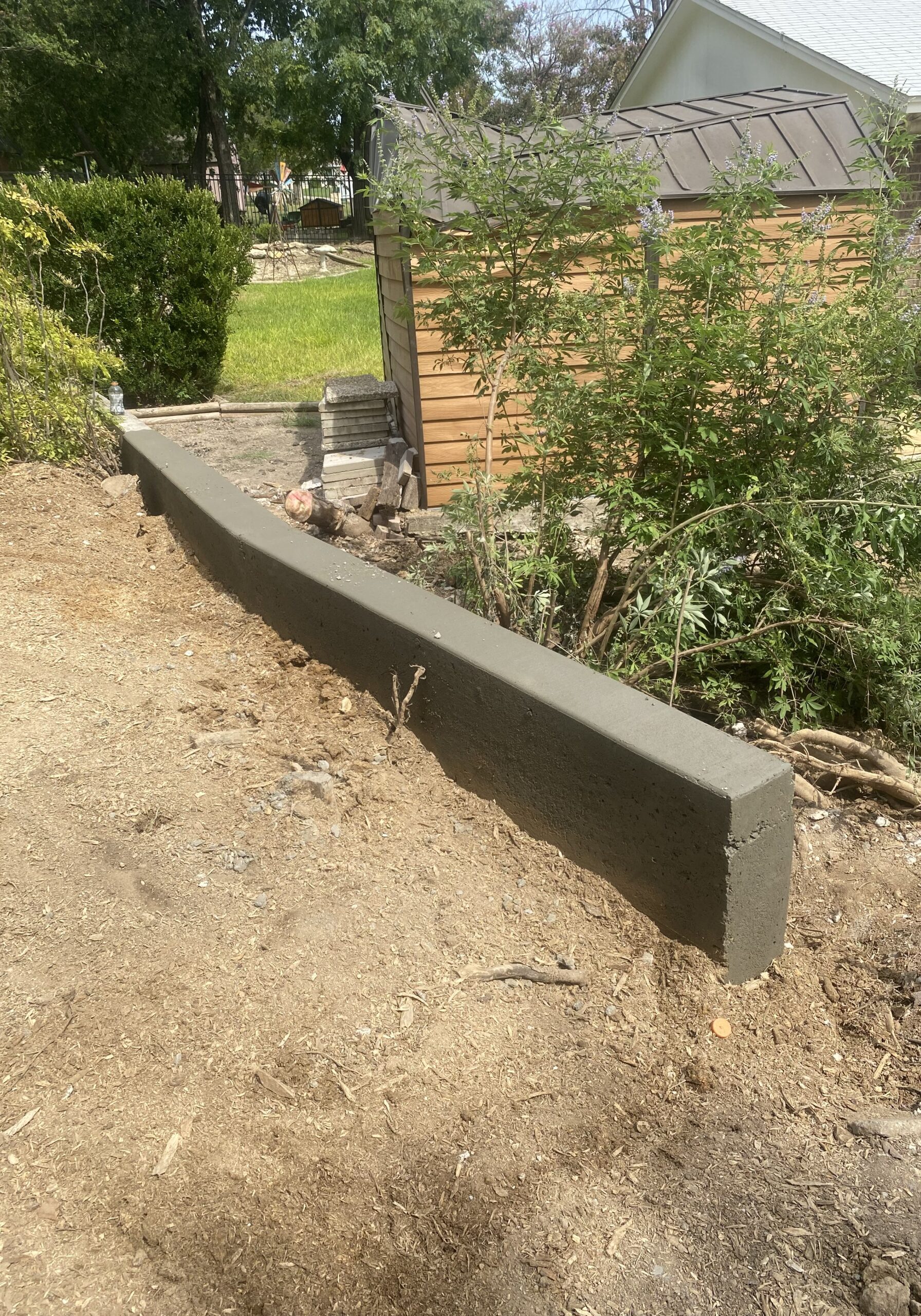 concrete-retaining-wall-installation-central-texas.jpg Custom concrete retaining wall installation designed for erosion control and landscape support at a residential property in Central Texas.